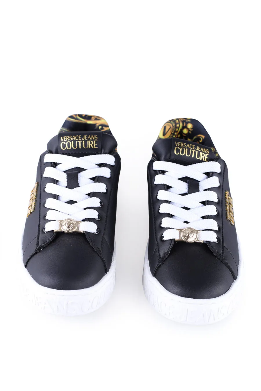 Zapatillas negras con suela blanca y logo dorado